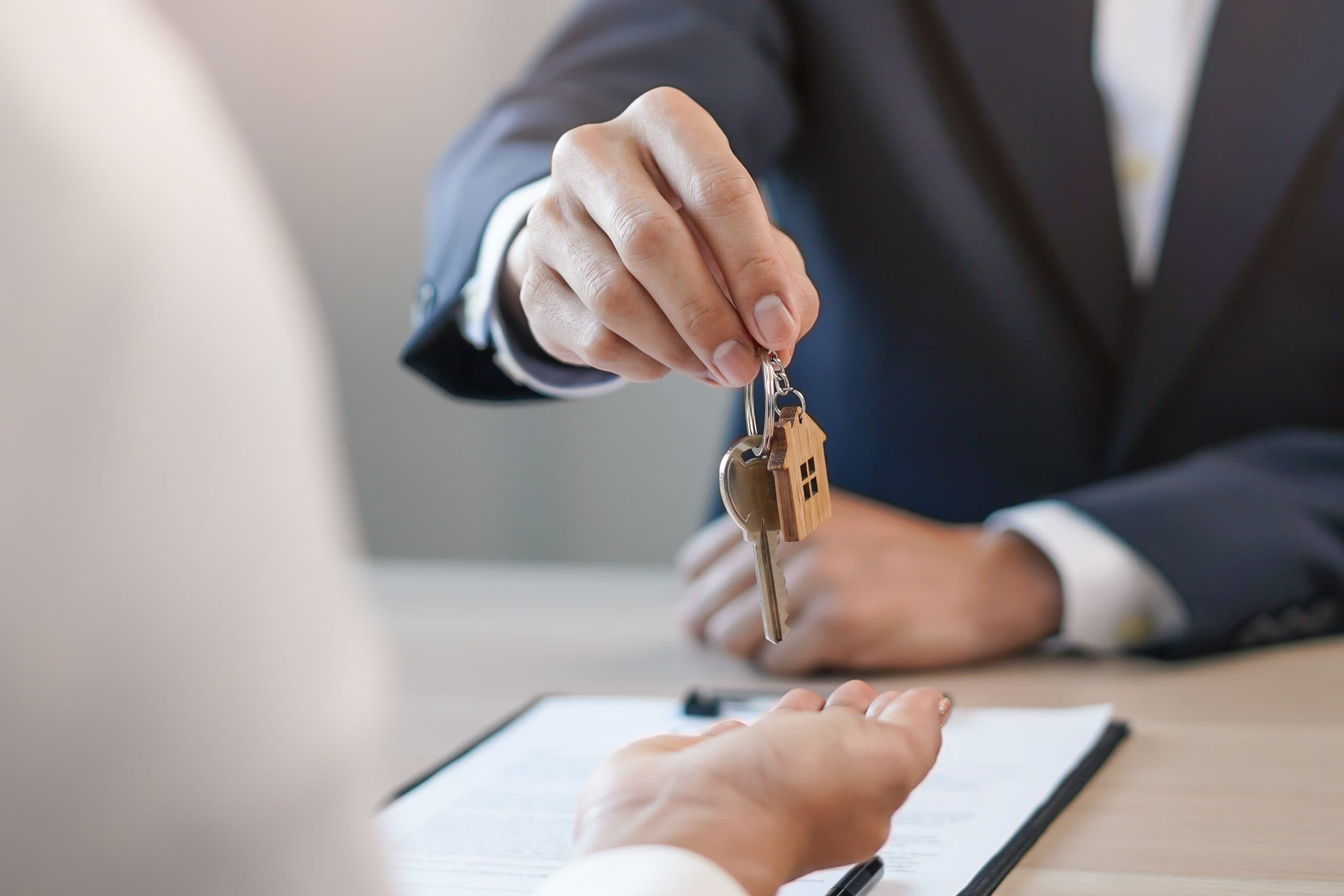 Handover of the house key with its house shaped fob after a completed sale